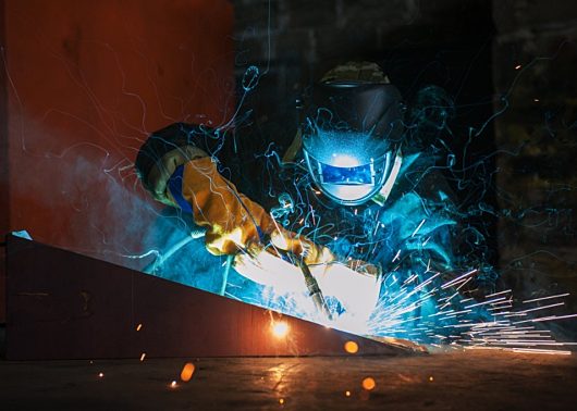 worker using a welding torch on metal